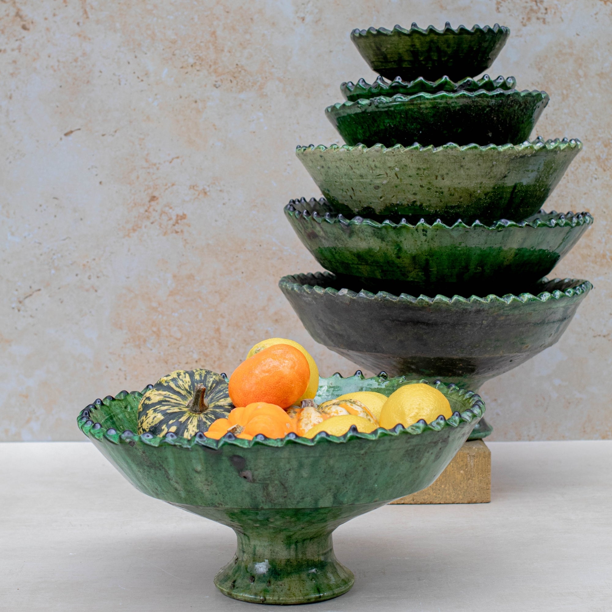 Authentic Tamegroute pottery bowl, handmade in the village of Tamegroute, southern Morocco. Every bowl is hand-thrown from local mineral-rich clay and finished with the village's signature deep green glaze. Fired in underground wood-fired kilns using centuries-old techniques, the heat creates natural variations in tone and texture across each piece. The glaze reacts organically to the kiln fire, producing distinctive emerald-to-moss tones with subtle bronze highlights. No two bowls are identical.
Perfect as