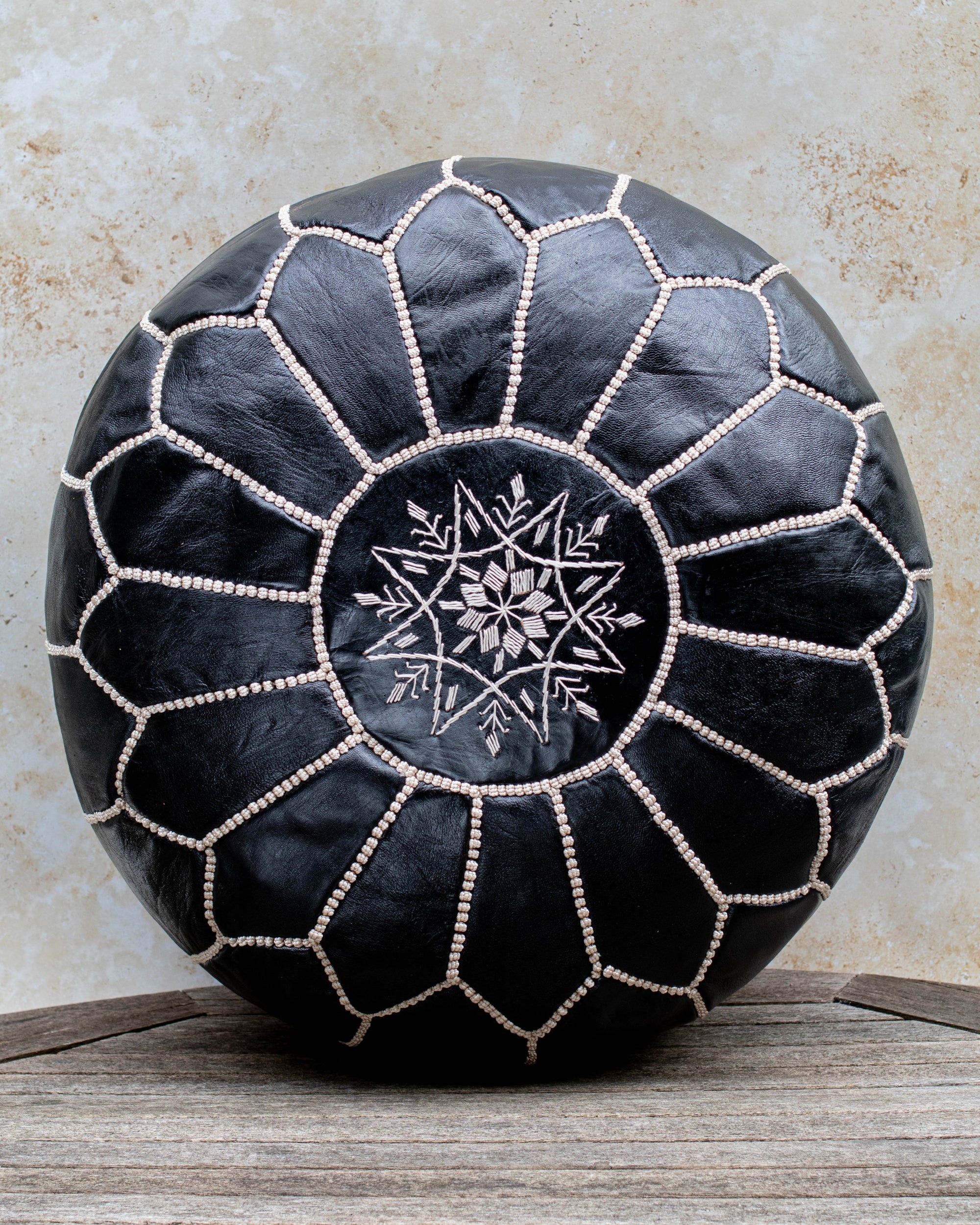 Black Moroccan leather pouf with beige stitching front view