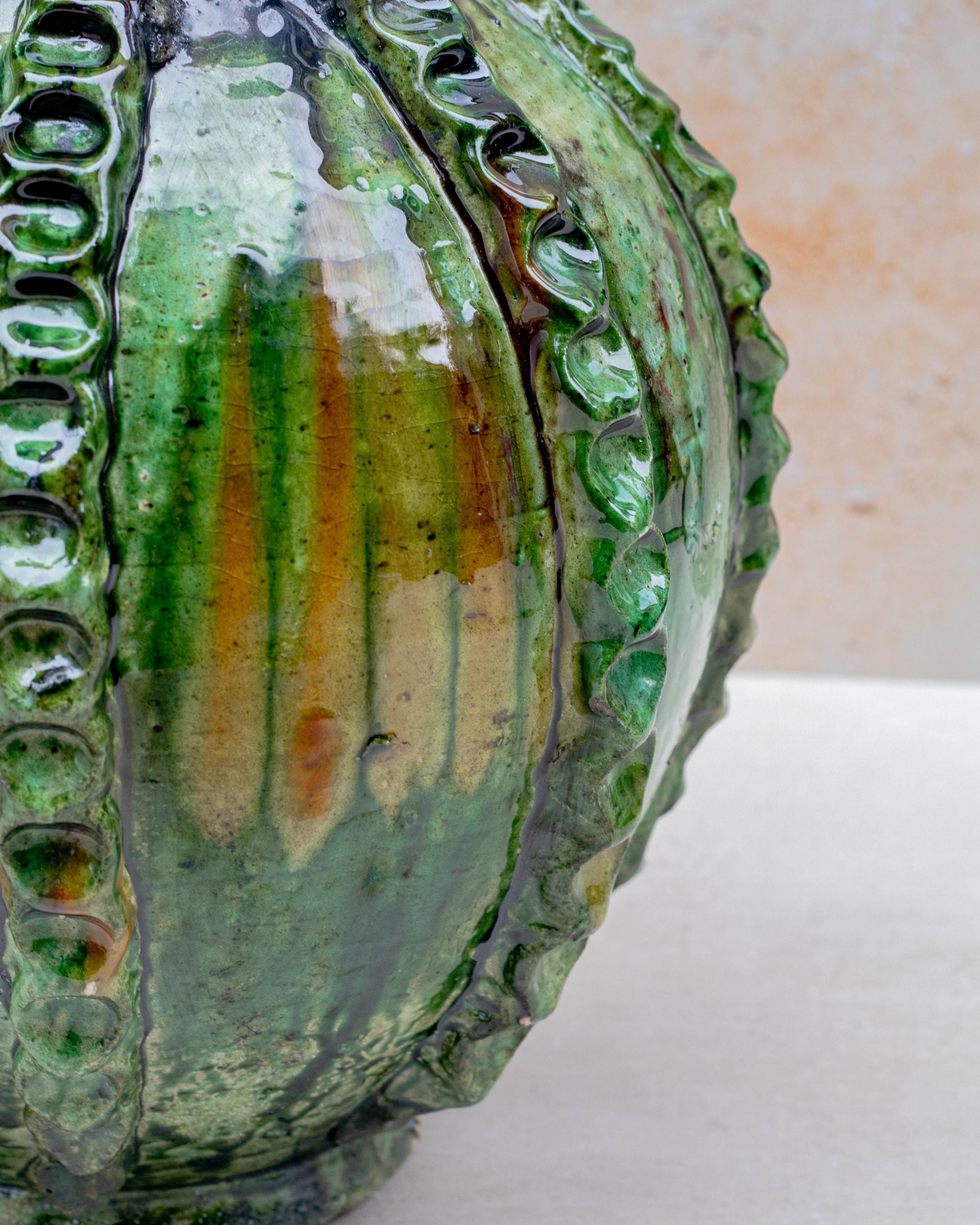 Glossy green ceramic vase on neutral background
