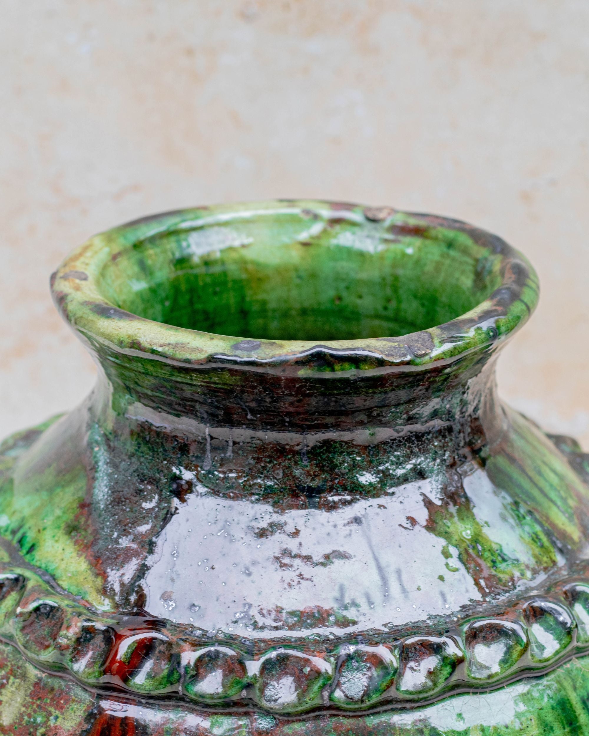 Green ceramic vase with bronze accents and hand-carved detailing