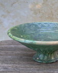 Green pedestal bowl filled with fruit — artisan Moroccan pottery