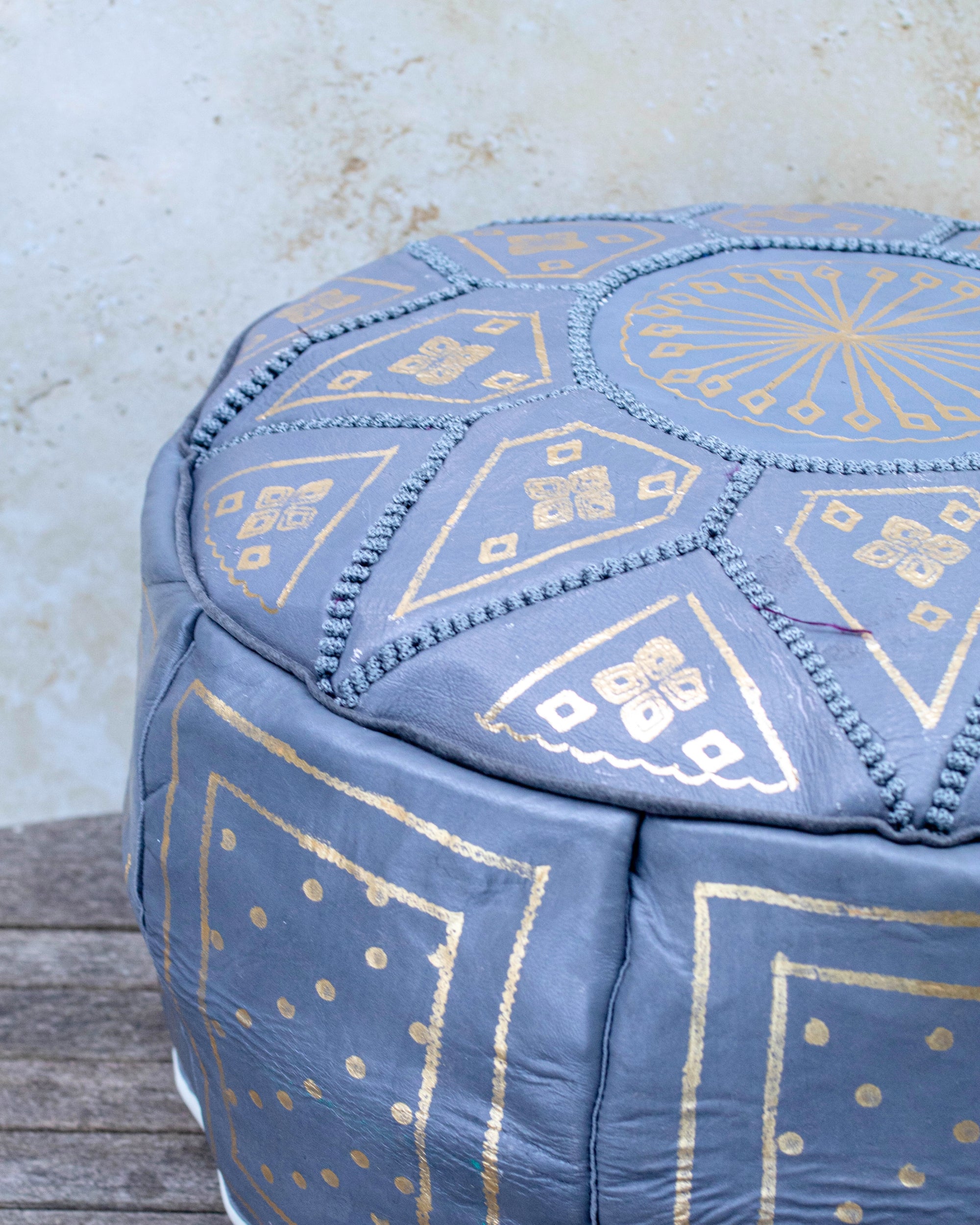 Grey and gold Moroccan pouf styled as ottoman in living room