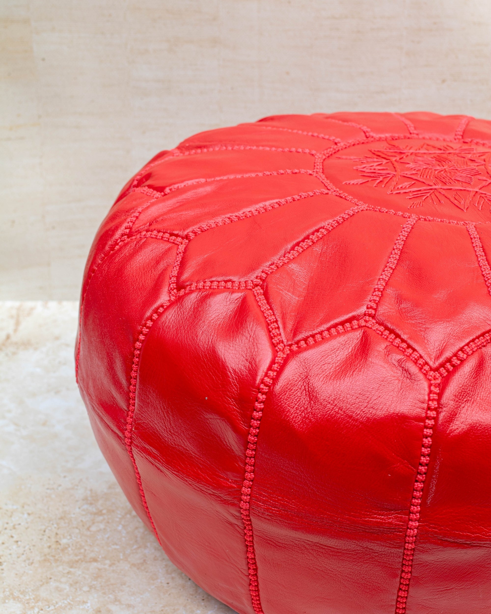 Red pouf styled in living room as ottoman